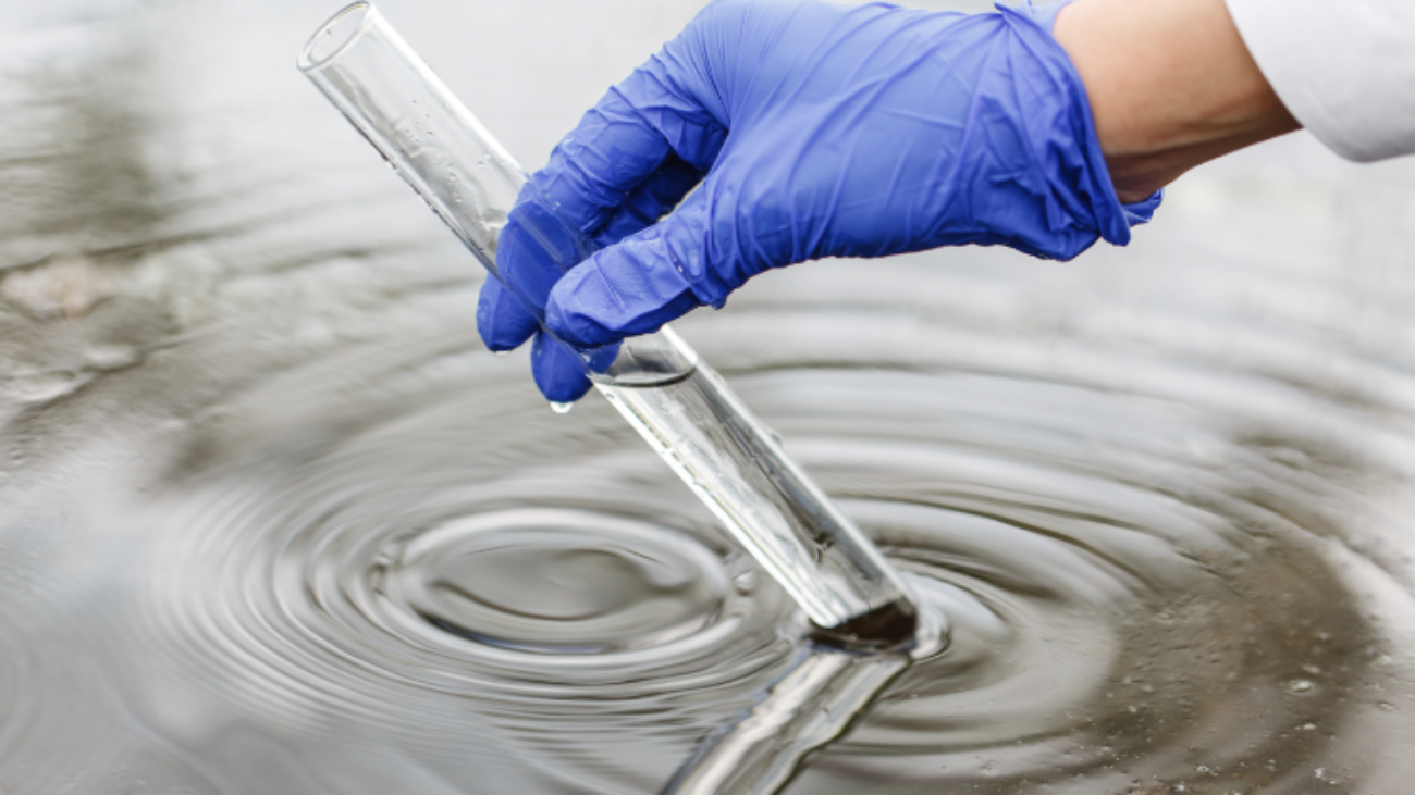 researcher-holds-test-tube-with-water-hand-blue-glove